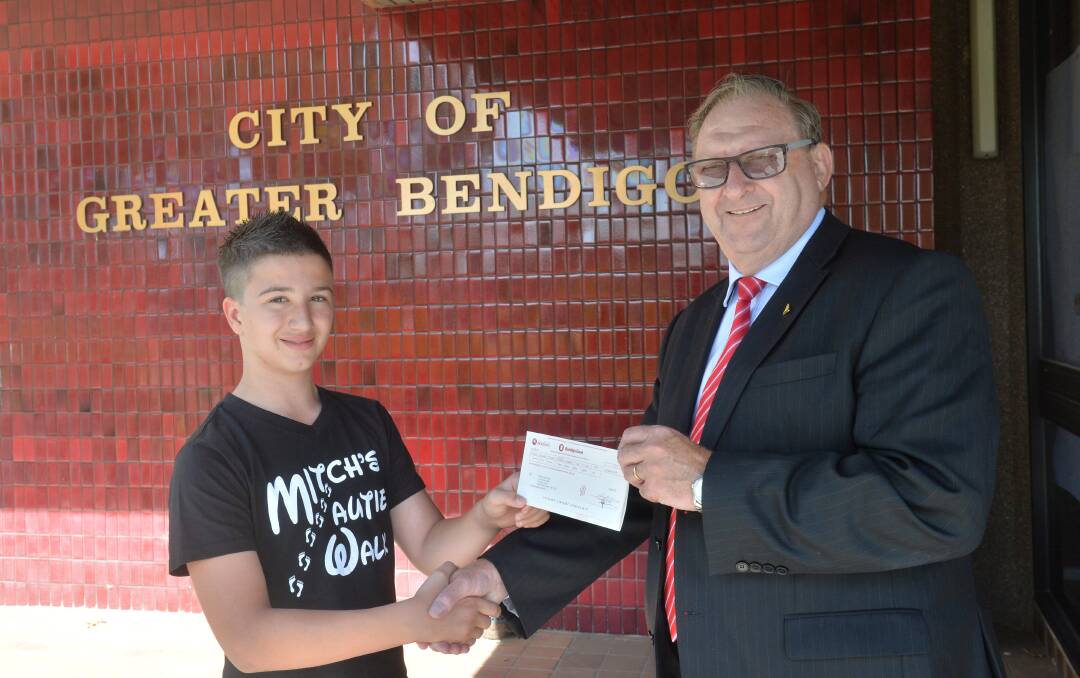 Mayor Barry Lyons handing $2000 cheque to Mitch Bourke for his Autie walk - a walk to raise money for autism centre in Bendigo 
Picture: PETER WEAVING