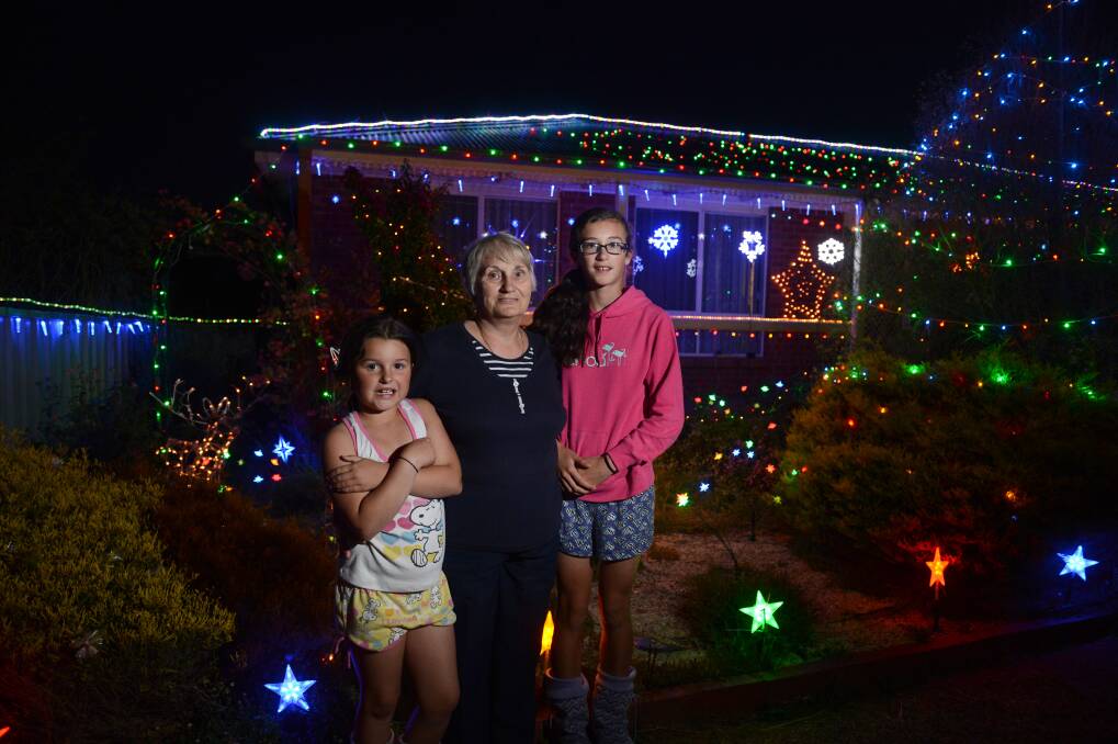 Amahli Lovell, Myrtle Darby and Taylor Lovell look at Christmas lights on a house in Excell st. Picture: JIM ALDERSEY