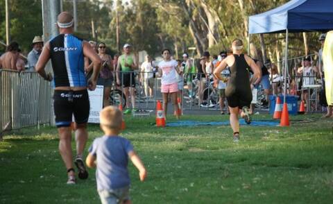 A HUSBAND'S LOVE: Ben McDermid crosses the finish line after wife, Lisa, with son Jonty behind. PICTURE: EVAN LENNON.