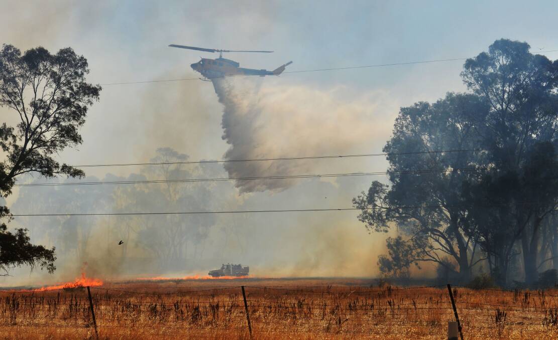 QUICK RESPONSE: Firefighters battle the blaze at Maiden Gully on Sunday.