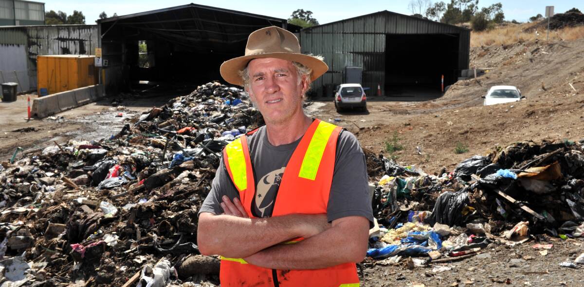 WASTE: Simon Clay at the scene of the fire with burnt rubbish. Picture: BLAIR THOMSON