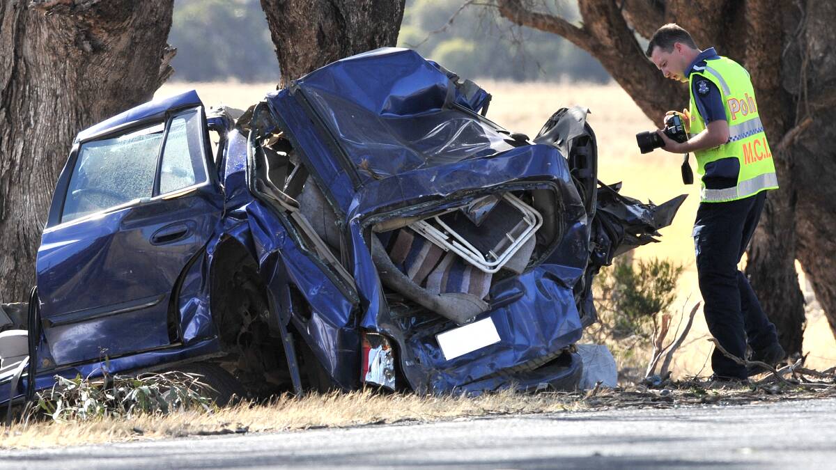 DOUBLE FATALITY: Police inspect a car which two men died in. Picture: BLAIR THOMSON
