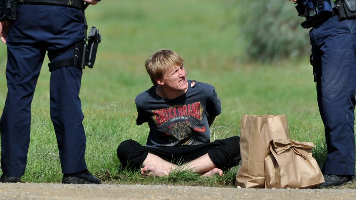 ARREST: A man is arrested in a field near Bendigo Pottery on Monday. Picture: JODIE DONNELLAN