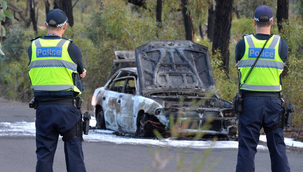 BURNT: Police look at a burnt out Subaru in Long Gully. Picture: BLAIR THOMSON