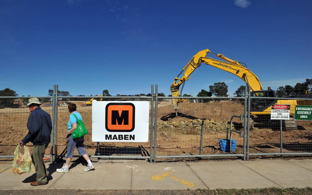 START: A couple walks past the site of a new supermarket precinct in Kennington. Picture: BLAIR THOMSON