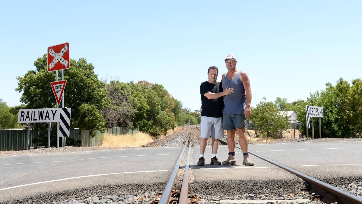 RELIEVED: Enzo Scafati with his son-in-law Jeff Martin at the Southey Street railway crossing. Pictures: JIM ALDERSEY