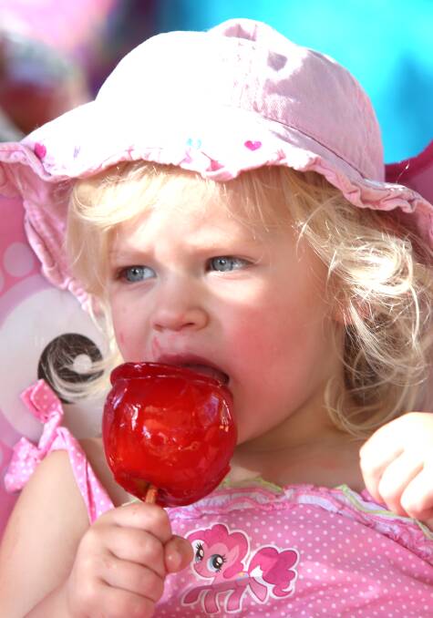 Ruby Hudson, 2, enjoys a toffee apple.