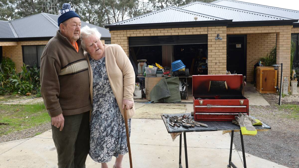 SHOCKED: Edwin and Jennifer Hicks in their driveway, where their utility was stolen. Burnt tools recovered from the wreck are in the foreground. Picture: JIM ALDERSEY