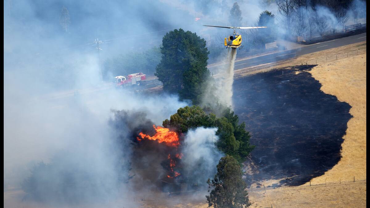 A helicopter douses flames at Gisborne. Picture: SIMON O'DWYER, Fairfax Media