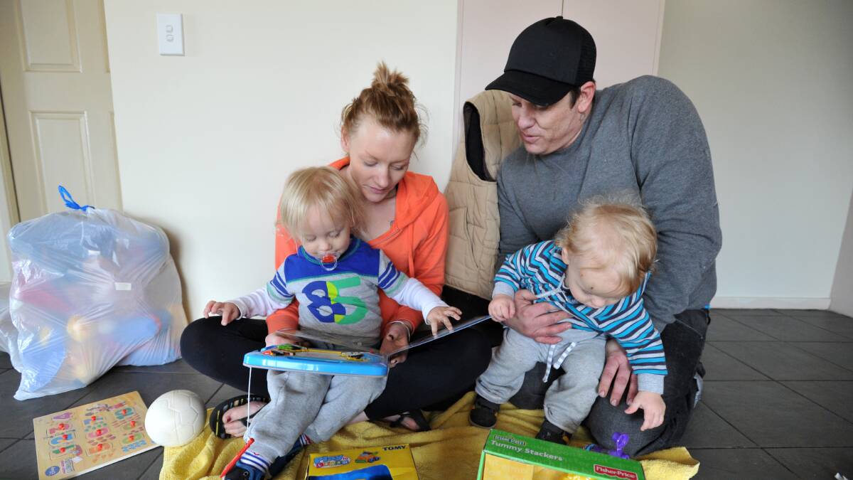 SETTLING IN: Belinda Fowler and Ben Dougherty and their children Braxton, 2 and Phraze, 1, play with some donated toys.