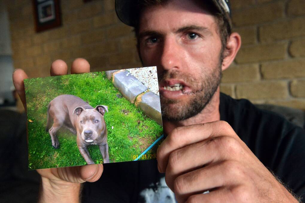 LOST: Daniel Hunter with a photo of his missing dog, Stornch. Picture: BRENDAN McCARTHY