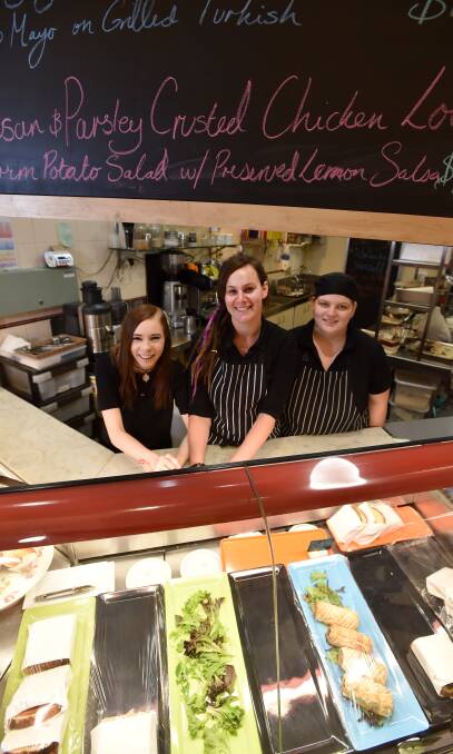 SOCIAL: Youth worker Shannon Ryan, centre, with staff members Mady Eastwood and Bec Kellett at hospitality training cafe Sidetracked Canteen. Picture: JODIE WIEGARD.
