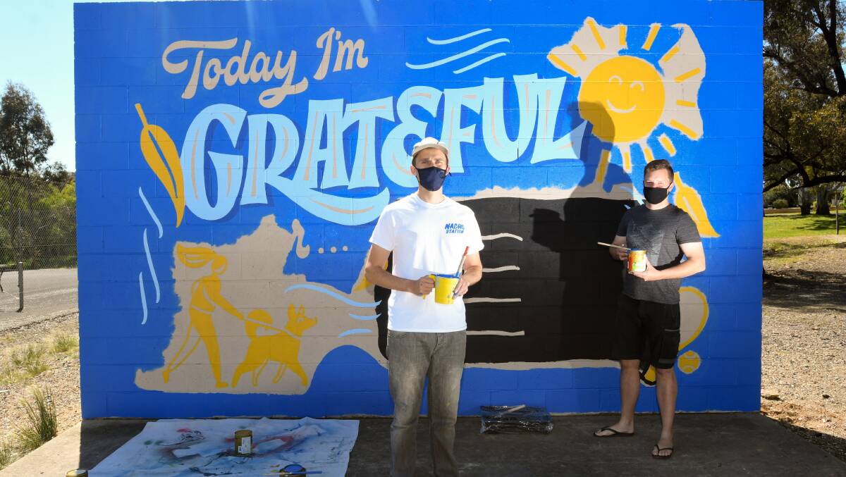 Artist Wes Franklin with helper William Louis at the Quarry Hill mural. Picture: NONI HYETT