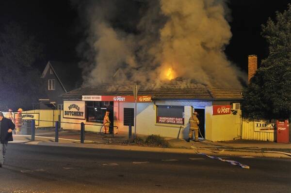 BLAZE: Fire crews fight a fire in the roof space of two McIvor Road stores in Bendigo. Picture: JIM ALDERSEY