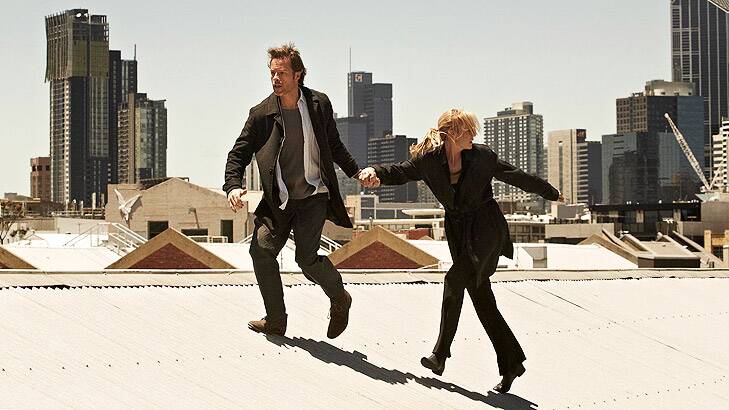 Jack Irish (Guy Pearce) and Linda Hillier (Marta Dusseldorp) flee across rooftops.