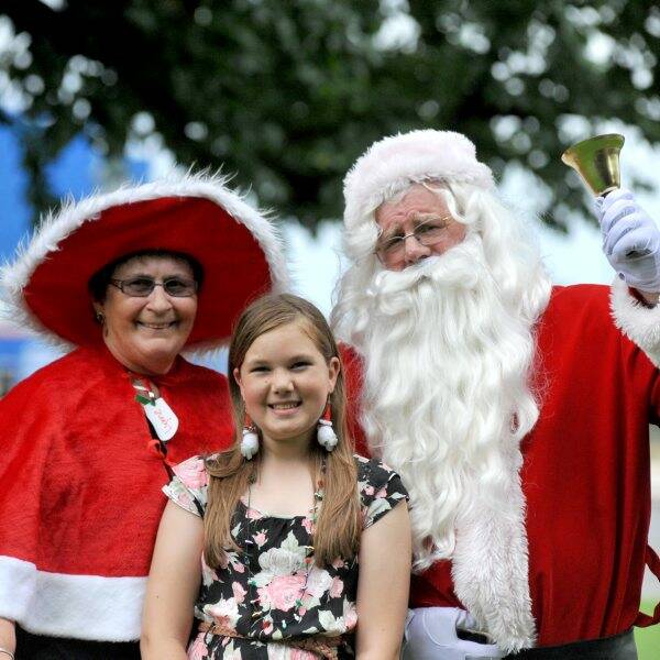 MERRY: Mackenzie Furness-Pearce gave up her Christmas Day to volunteer at the Community Christmas lunch at the Bendigo Town Hall. She is pictured with Mrs Claus and Santa.