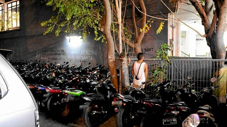 A man urinates at the Bali bombing site, where the Sari Club used to stand. The site is now a car park.