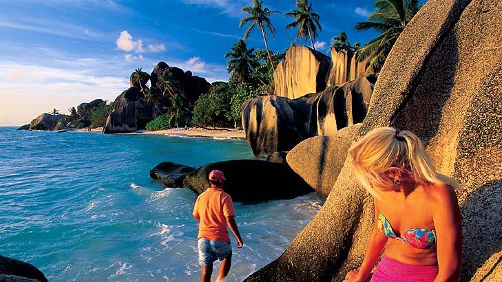 50 Places of a Lifetime ... visitors explore Anse Source d'Argent Beach on La Digue island, Seychelles.
