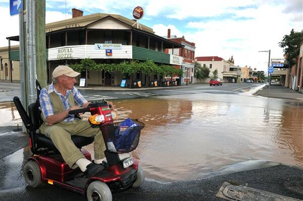 Inglewood resident Tom Lovett surveys the town’s flooded main road. Picture: alex ellinghausen