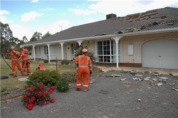 CLEAN-UP: SES members inspect the damage.