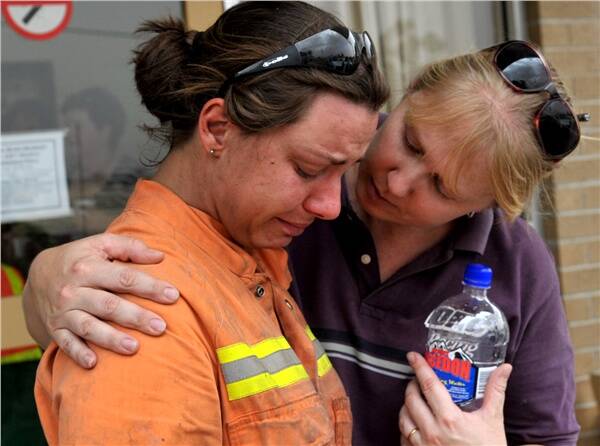 LEAN ON ME: Sandra Rickard is comforted after losing her home in the Redesdale bushfire.qm
