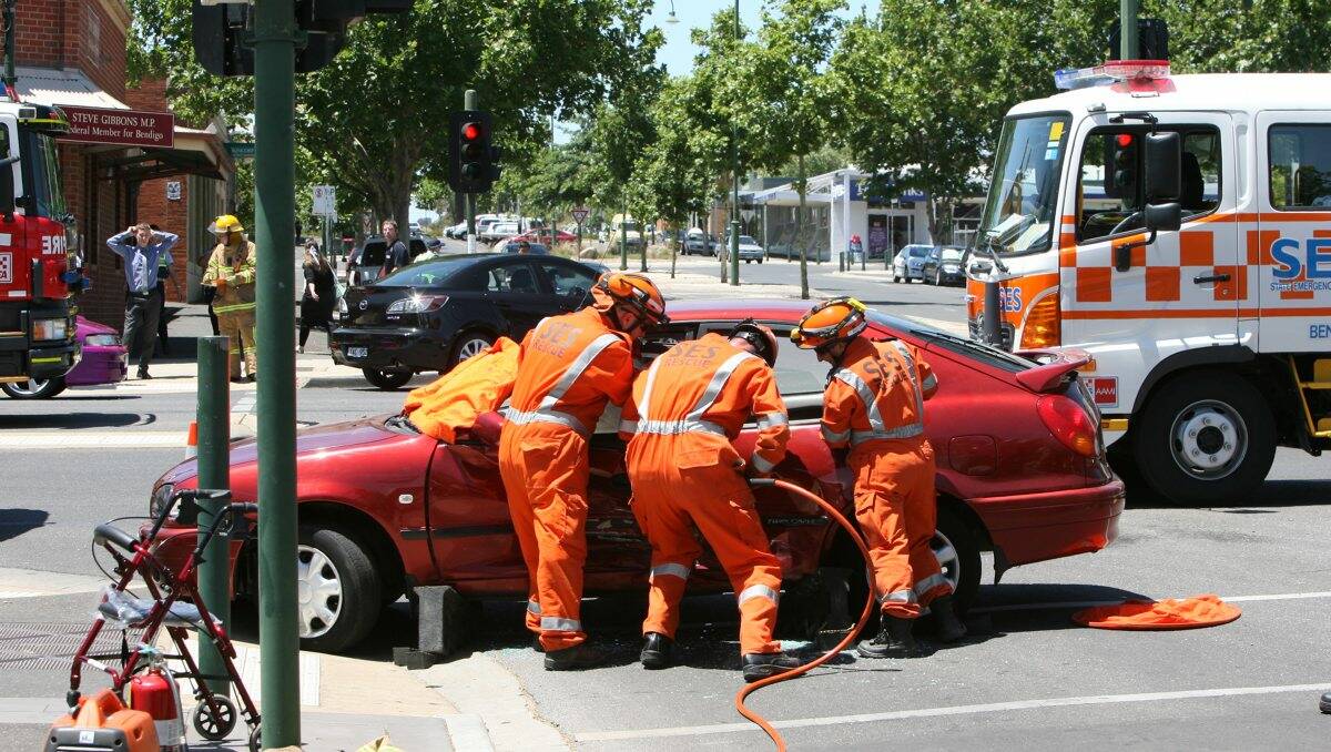 RESCUE: SES members work to free the woman from the damaged car. Picture: PETER WEAVING
