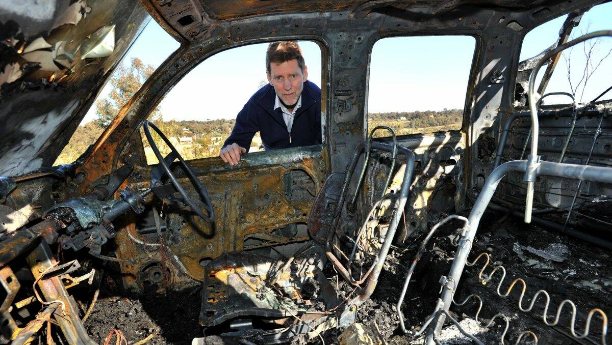 Destroyed: Laurie Whelan with the burnt-out shell of his business The Good Loaf Sourdough Bakery & Cafe’s delivery vehicle, which was stolen from his house yesterday morning.    Picture: Peter Weaving