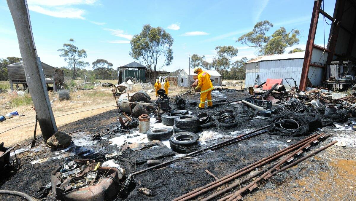 CHARRED: CFA members at the scene of yesterday’s fire. Picture: PETER WEAVING