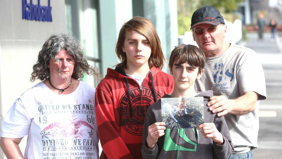 Boe Norton-Doidge shows a picture of the dog attack as family members Sharlene, Clayton and Tom look on. Picture: PETER WEAVING