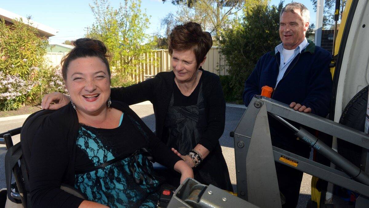 Kim Barlow leaves for the ball with help from Deidre Chapman and taxi driver Alan Summers. Picture: BRENDAN McCARTHY