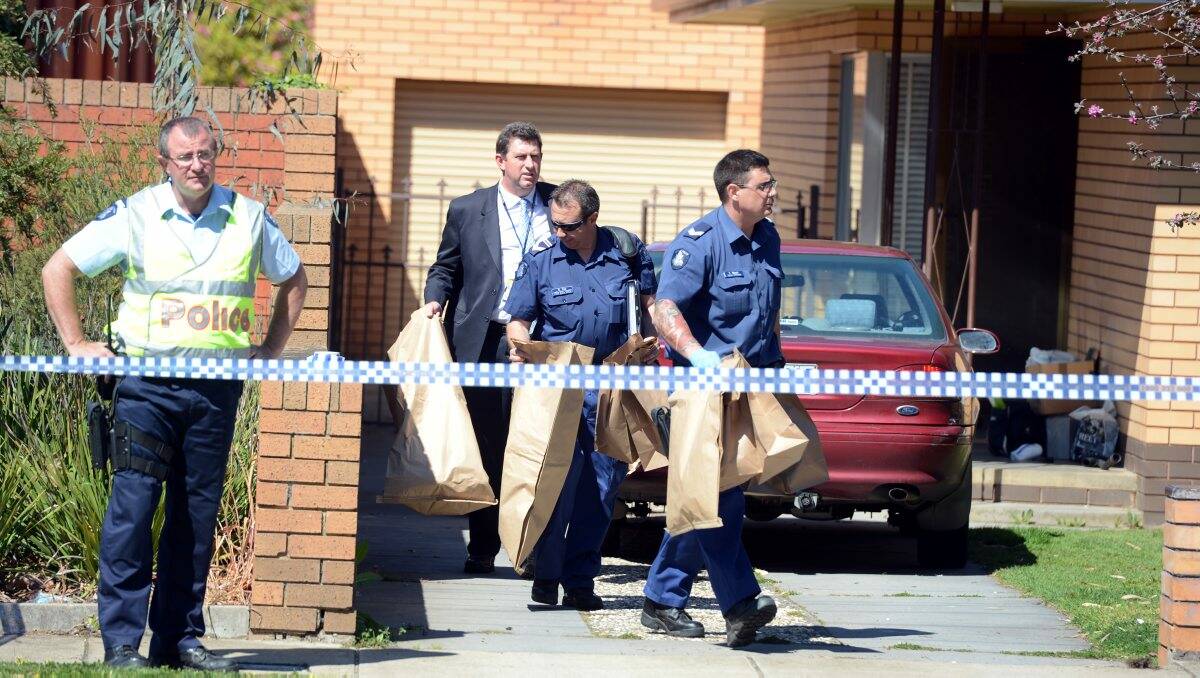 Police take evidence bags away from the home where the baby was injured. Picture: JIM ALDERSEY
