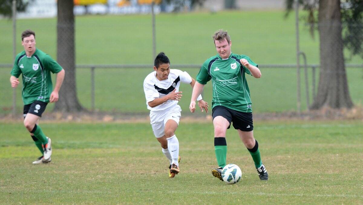 ON TARGET: The Raiders' Alister Holt is pursued by Golden City's Eh Soo She in Sunday's division one match at Shadforth Park. Picture: JIM ALDERSEY