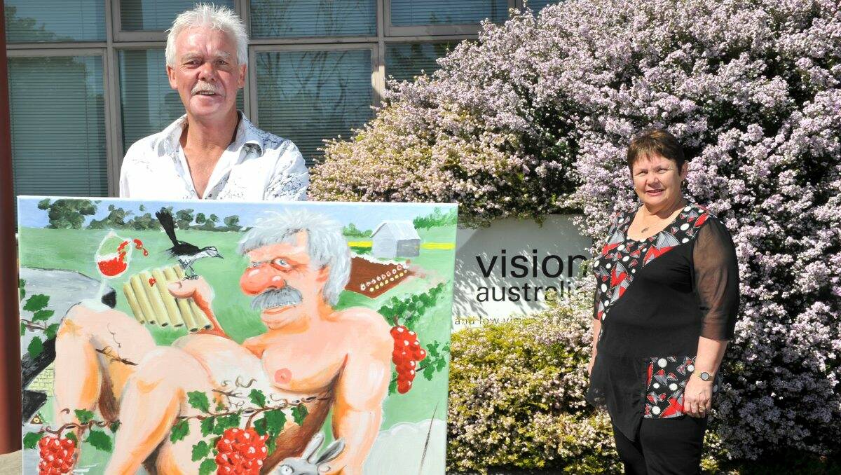Ross Lougoon from Connor Park Winery with his painting Back to the Future, which will be auctioned for charity on Friday, and Vision Australia Bendigo manager Ruth O’Connell.