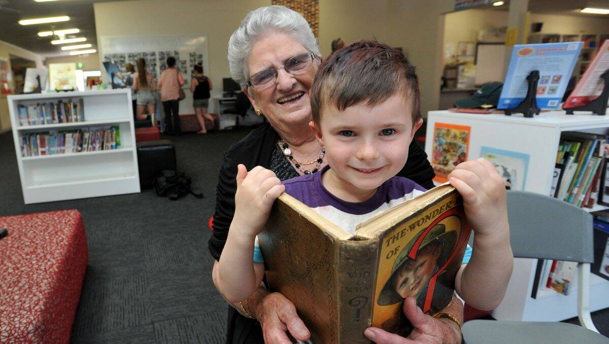 Former Eppalock Primary pupil Moira Mace shares an old book with current prep student Levi Bowe.