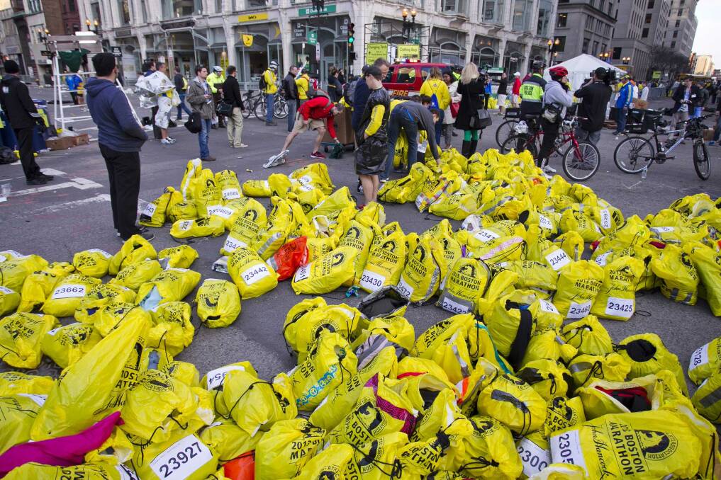 Volunteers organize participants for belongings for collection after two explosions interrupted the running of the Boston Marathon in Boston. Photo: Reuters