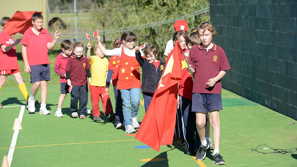 Kieran Tuohey leads China in the opening ceremony at Goornong Primary School, the students dressed up in team colours for the schools mini Olympics. Photo Jim Aldersey