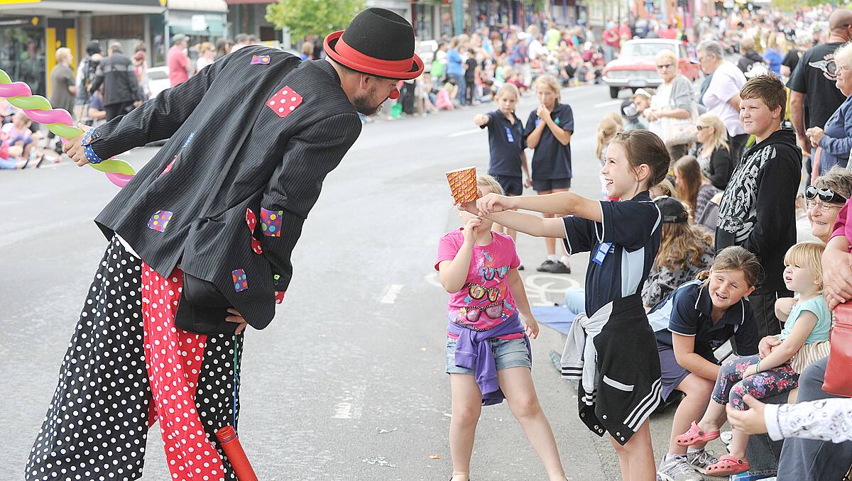 Lexi Hall, 9 offers a swap with a clown from the parade, her chips for a balloon animal. Picture: Jodie Donnellan.