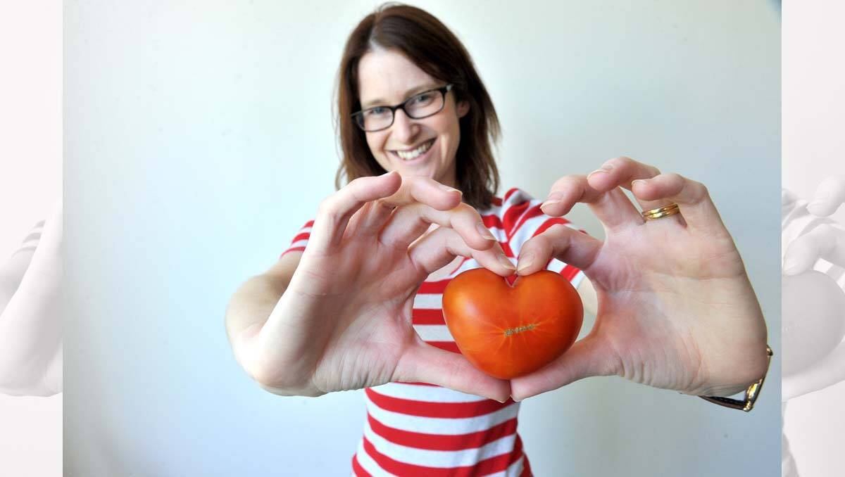 Lauren Mitchell holds a home-grown tomato in the shape of a love heart. Picture: Jim Aldersey