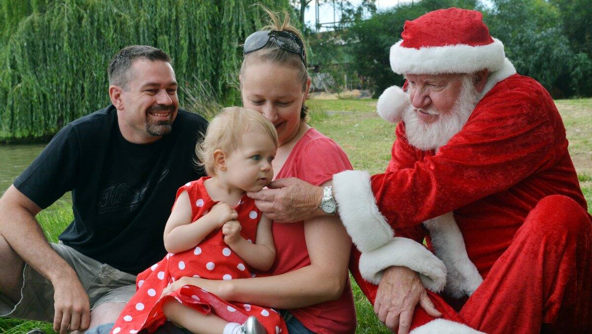 MADE FOR THE ROLE: One-year-old Jordan Rinaldi, with dad Darren and mum Leah, meets Santa at Bendigo’s Lake Weeroona. Picture: BRENDAN McCARTHY