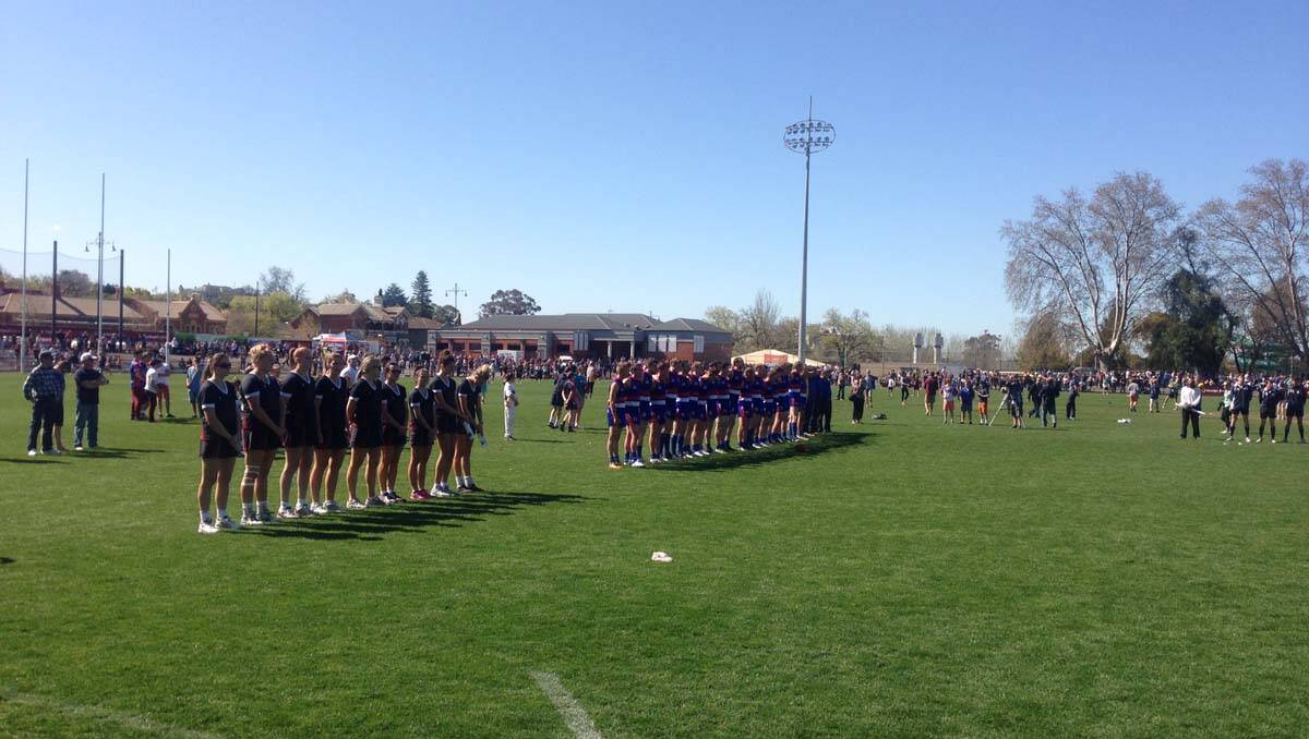 Football and netball teams stand for the national anthem at the QEO. Picture: Jim Aldersey