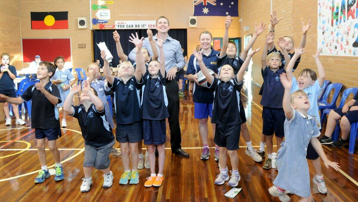 ACTIVE: YMCA CEO Michael Bailey and Bendigo Spirit captain Kristi Harrower with students from Eaglehawk North Primary School playing with beach balls.Picture: JODIE DONNELLAN  
