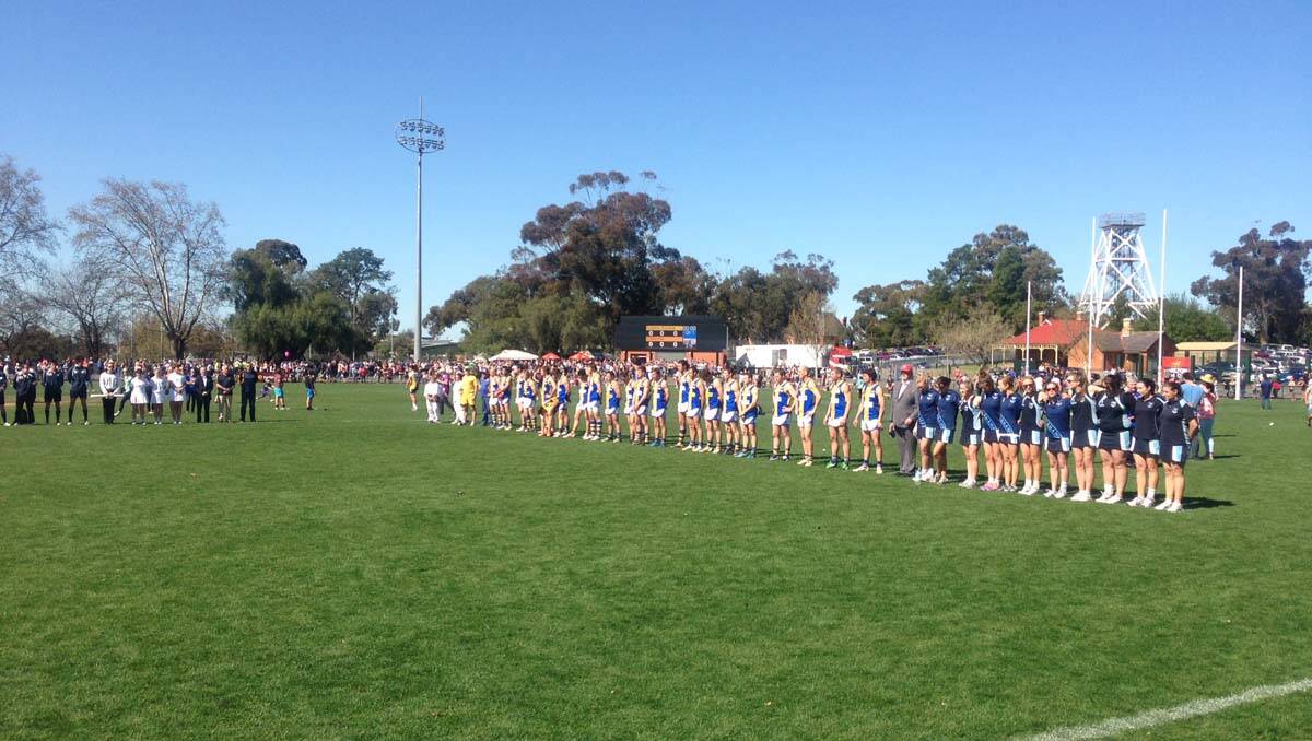 Football and netball teams stand for the national anthem at the QEO. Picture: Jim Aldersey