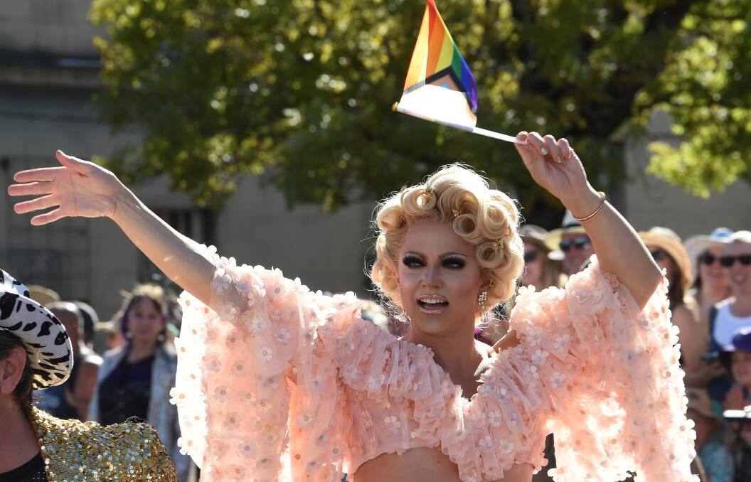 Courtney Act caught in the act of waving to fans at the ChillOut Festival parade. Picture by Lachlan Bence