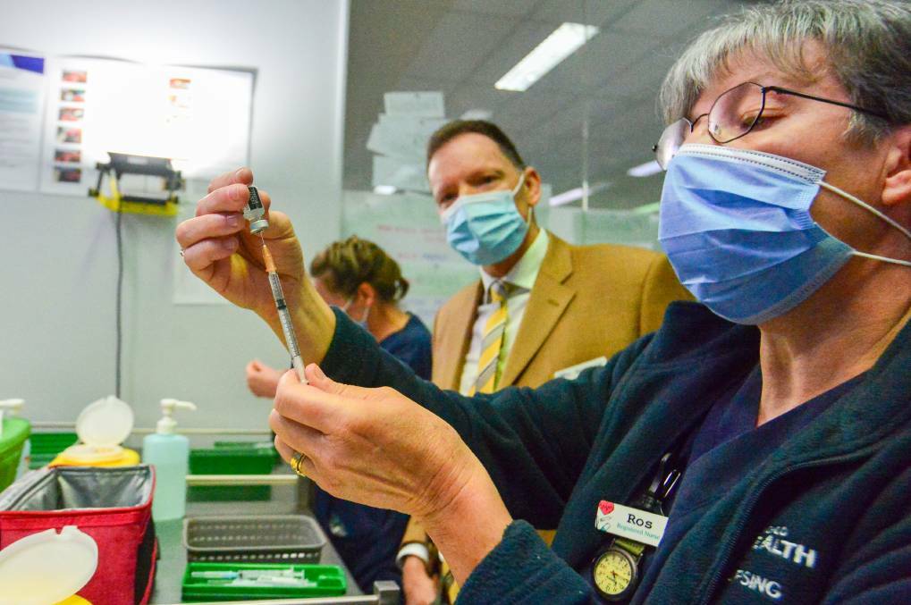 VAX THE NATION: Bendigo Health chair Bob Cameron watches on as one of his staff members prepares a COVID-19 vaccine dose. Picture: DARREN HOWE