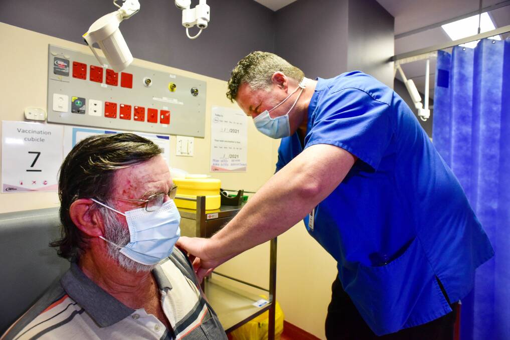 NEXT STEP: Ken Morton receives his COVID-19 vaccination from nurse Tim Callahan at Bendigo Health during a new stage of the rollout. Picture: BRENDAN McCARTHY