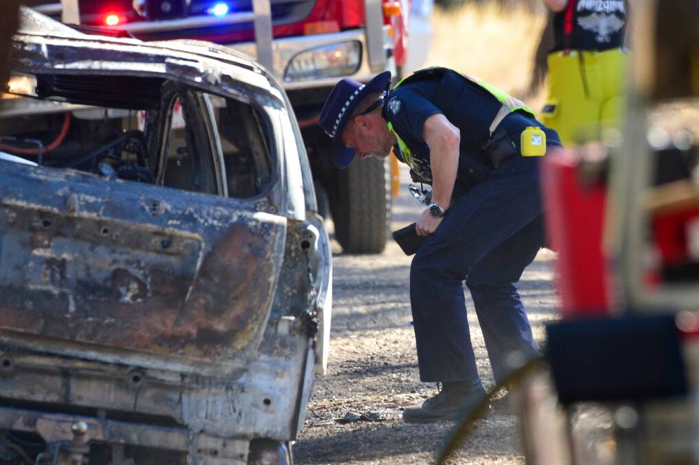 LUCKY ESCAPE: Police investigate a burnt out car at Woodvale. Picture: DARREN HOWE