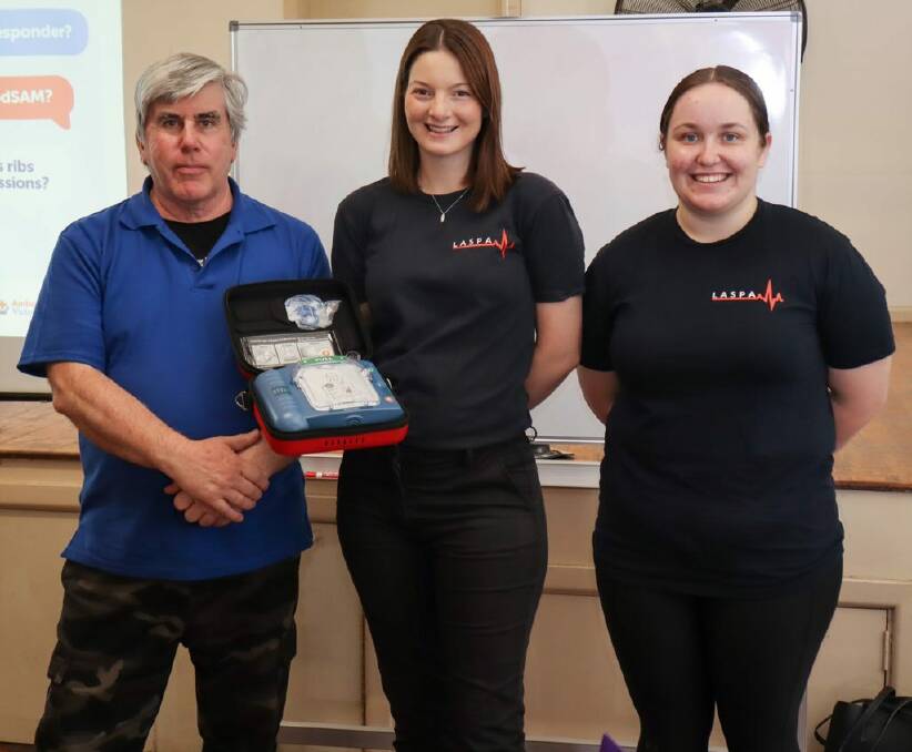 LASPA representatives Matilda Henley-Johnstone and Zoe Biggs presenting the defibrillator to BAREC president Neil Patton. Picture: SUPPLIED