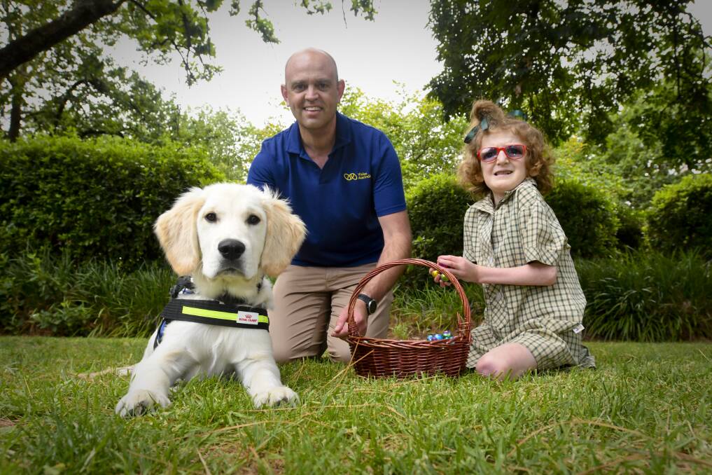 LOYAL SERVICE: Vision Australia's Adam English with Seeing Eye Dog pup Deuce and Lucy Symes. Picture: NONI HYETT