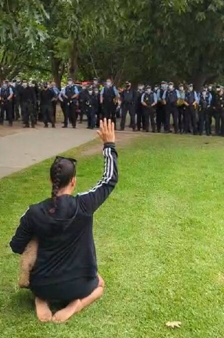 A protester puts her hand up in front of police. Picture: Facebook