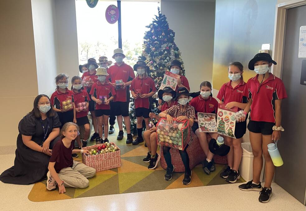 Bendigo Health acting nurse unit manager Kate Lim with Epsom Primary School students delivering gifts and decorations to the children's ward at Bendigo Health. Picture by David Chapman